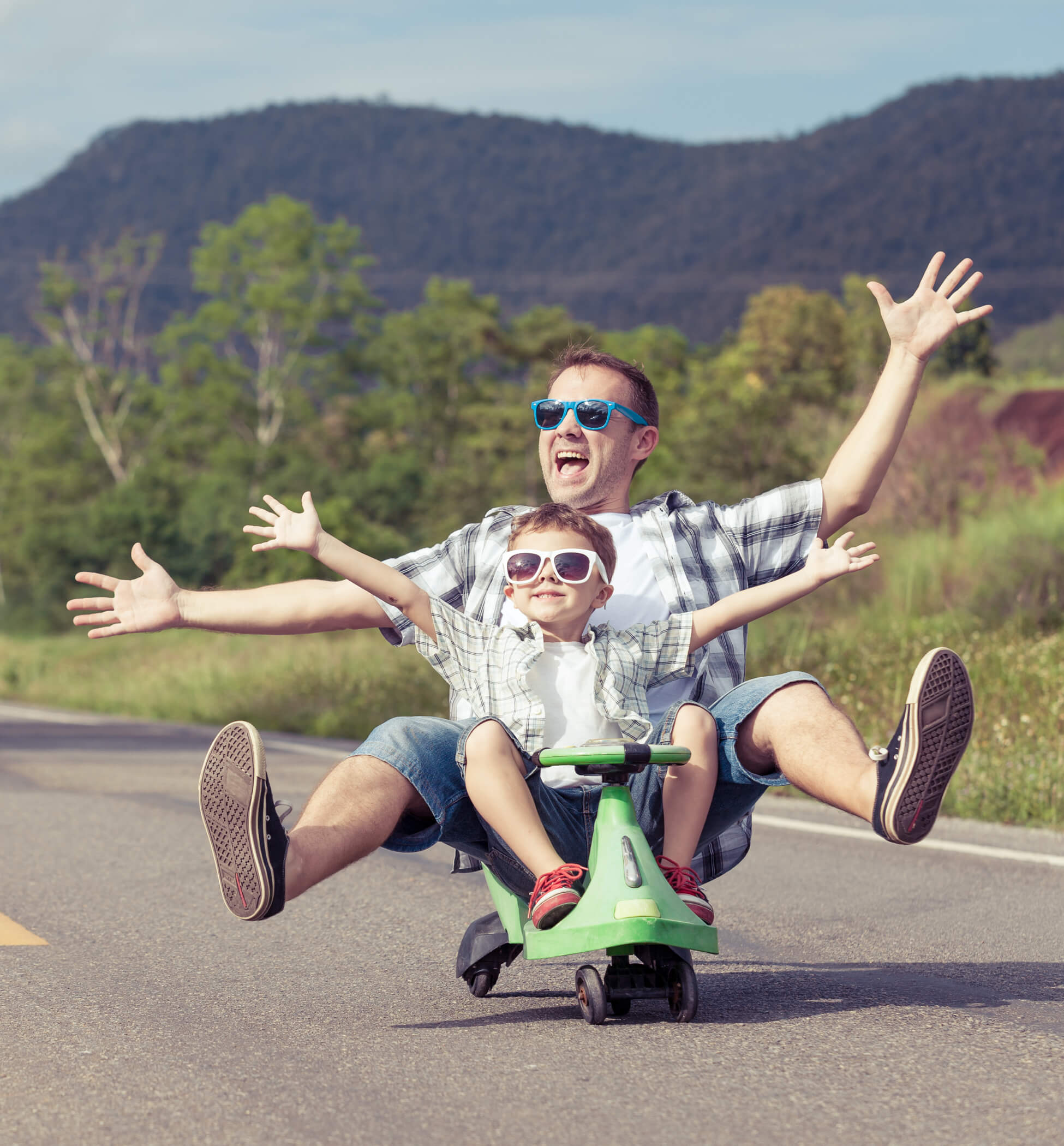 Photo of a father and son skateboarding down a hill